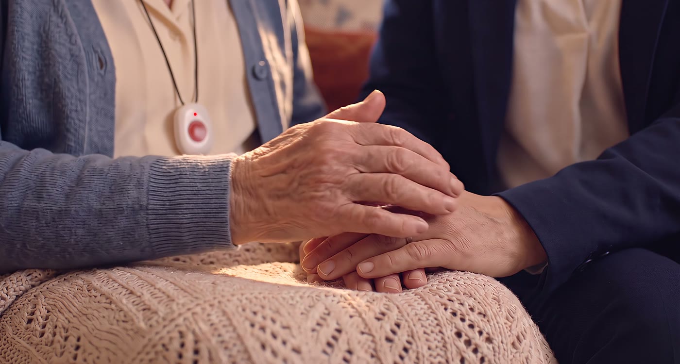 Manos de madre e hija; la madre lleva la medalla